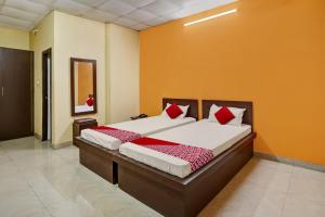a bedroom with a bed with red and white pillows at OYO Flagship Sanskar Garden in Rānchī