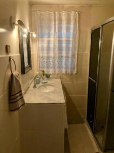 uma casa de banho com um lavatório e um chuveiro com uma janela em Catavento Pousada em Alto Paraíso de Goiás