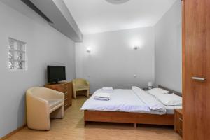 a bedroom with a bed and a tv and a chair at Central Apartament Predeal Nr 4 in Predeal