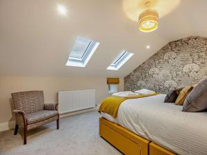 um quarto com uma cama, uma cadeira e clarabóias em 2 Bed in Ennerdale 93196 em Ennerdale Bridge