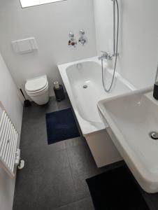 ein Badezimmer mit einer Badewanne, einem WC und einem Waschbecken in der Unterkunft Ferienwohnung Am Stadtpark in Chemnitz