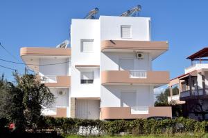 a white building with balconies on the side of it at ADONIOS APARTMENTS in Archangelos