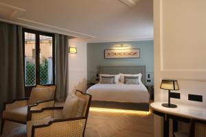 Habitación de hotel con cama, mesa y sillas en Eunice Hotel Gastronómico en Salamanca
