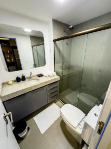 uma casa de banho com um WC e uma cabina de duche em vidro. em Flat em Boa Viagem Rooftop 470 Conforto e Localização privilegiada no Recife