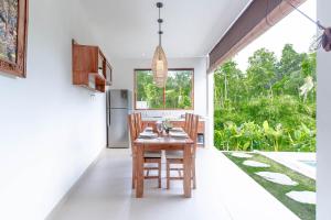 a kitchen and dining room with a table and chairs at Jenar Ubud Villa in Ubud