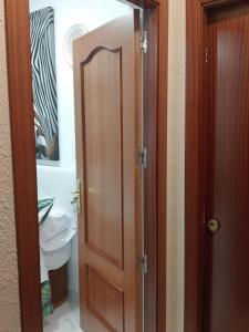 a bathroom with a wooden door with a mirror at Moneiba Centro in Córdoba