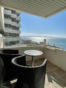 una mesa y sillas en un balcón con vistas al océano en PALMA BEACH HOTEL Adults Only, en Can Pastilla