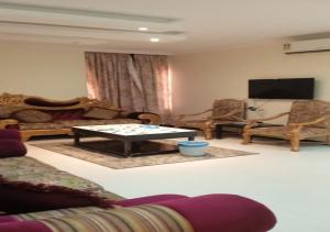 a living room with a couch and a table and chairs at فندق سما اشبيليه الرياض in Riyadh