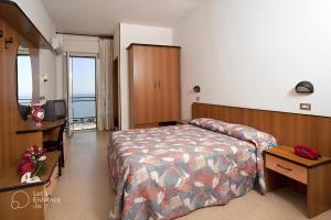 um quarto de hotel com uma cama e uma televisão em Hotel Spiaggia em Gatteo a Mare