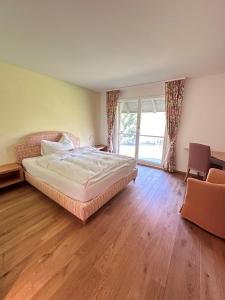 Schlafzimmer mit einem Bett, einem Schreibtisch und einem Fenster in der Unterkunft Parkforum Wylihof in Luterbach