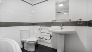 a white bathroom with a toilet and a sink at The Lodge - Exquisite 2 Bed with Ensuite in Birmingham