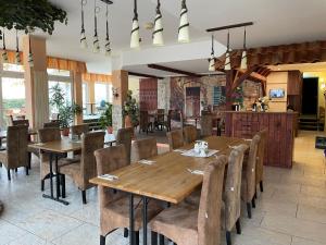 a dining room with wooden tables and chairs at REGIOHOTEL Halle Leipzig Airport in Schkeuditz