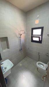 a bathroom with a toilet and a sink at Sand House ساند هاوس in Al Raka