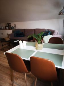 a table and chairs in a living room with a couch at Helle´s casa in Herning