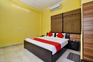 a bedroom with a large bed with red pillows at OYO Flagship Maira Residency in Dehradun