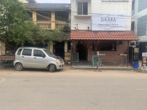 a white van parked in front of a building at Hotel Sikara, Kumbakonam in Kumbakonam