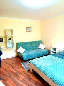 Zimmer mit 2 Betten und einem grünen Sofa in der Unterkunft Hotel Zemlinski in Payerbach