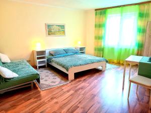 ein Schlafzimmer mit einem Bett, einem Sofa und einem Fenster in der Unterkunft Hotel Zemlinski in Payerbach