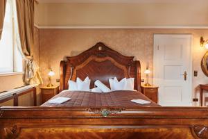 Un dormitorio con una gran cama de madera con almohadas blancas. en Residenz Hotel Wendorf, en Wendorf