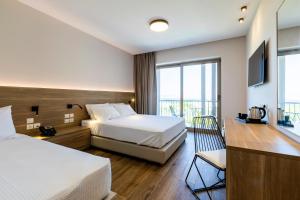a hotel room with two beds and a television at White Olive Premium Lindos in Pefki