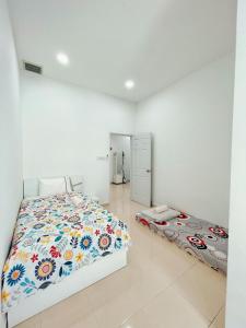 a bedroom with a bed with a floral comforter at Entire 4 BDR white house @ Yong Peng in Yong Peng