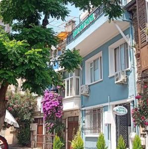 un edificio blu con dei fiori davanti di Buyukada Cinar Hotel a Büyükada