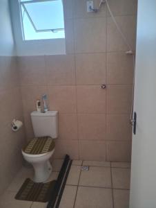 a bathroom with a toilet and a window at Apartamento Cabuçu in Nova Iguaçu