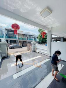 two men are painting the floor of a house at Entire 4 BDR white house @ Yong Peng in Yong Peng