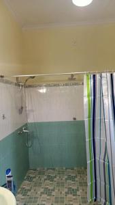 a bathroom with a shower with a shower curtain at Osh villa in Hikkaduwa +8 photos