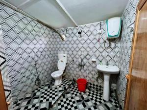 a small bathroom with a toilet and a sink at Hotel Green Gold Resort Lataguri in Lataguri