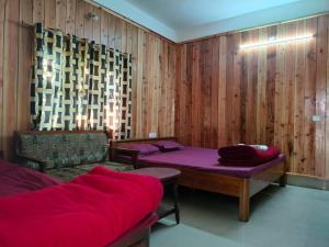 Habitación con 2 camas y sofá. en Hotel Green Gold Resort Lataguri, en Lataguri