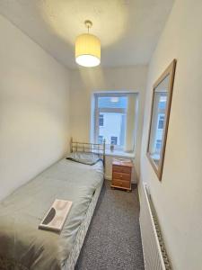 a small bedroom with a bed and a window at The perfect location when working in Swansea! in Swansea