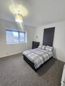 1 dormitorio con cama y ventana en The perfect location when working in Swansea! en Swansea