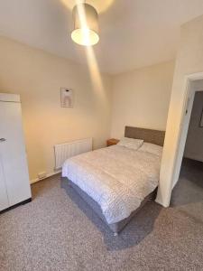 1 dormitorio con cama y luz en The perfect location when working in Swansea! en Swansea
