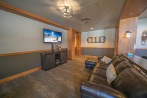 a living room with a couch and a flat screen tv at Expedition Station 8589 in Keystone