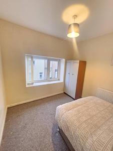 a bedroom with a bed and a window at The perfect location when working in Swansea! in Swansea