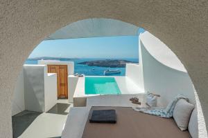 a room with a view of the ocean and a pool at Luxury Grand Santorini Villa - 3 Bedrooms - Unforgettable Caldera Sea Views and Outdoor Hot Tub - Fira in Fira