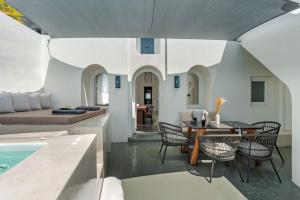 Il comprend une cuisine et un salon avec une table et des chaises. dans l'établissement Luxury Grand Santorini Villa - 3 Bedrooms - Unforgettable Caldera Sea Views and Outdoor Hot Tub - Fira, à Fira