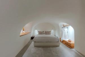 - une chambre blanche avec un lit dans une chambre blanche dans l'établissement Luxury Grand Santorini Villa - 3 Bedrooms - Unforgettable Caldera Sea Views and Outdoor Hot Tub - Fira, à Fira