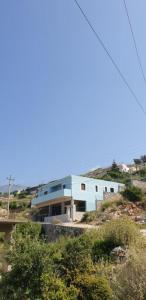 un edificio azul en la cima de una colina en Family Apartments Himara, en Himare