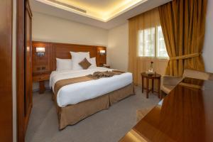 Habitación de hotel con cama grande y escritorio. en فندق روز جدة 2 en Yeda