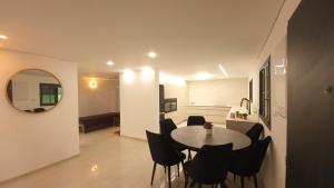 ein Esszimmer mit Tisch und Stühlen und einem Spiegel in der Unterkunft Y.L אירוח בוטיק in Bet Scheʼan