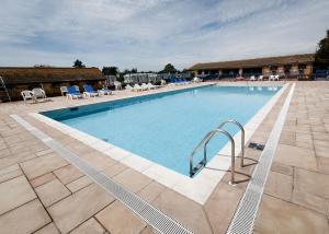 a large swimming pool with chairs and a hotel at Riverside Caravan Park in Bognor Regis