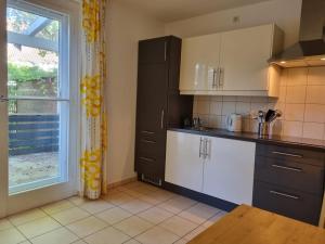 eine Küche mit weißen und schwarzen Schränken und einem Fenster in der Unterkunft BMS BALANCE - Gemütliche 4 Sterne Möblierung neben dem Parkhotel in Wolfsburg