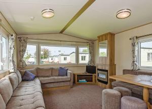 a living room with a couch and a tv at Riverside Caravan Park in Bognor Regis