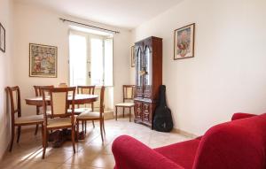 ein Wohnzimmer mit einem Tisch, Stühlen und einer Gitarre in der Unterkunft Cozy Apartment In Orsogna With Kitchen in Orsogna