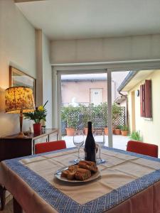 una mesa con una botella de vino y un plato de pan en Casa Mutti, en Asolo