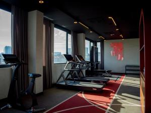 a gym with several tread machines in a room with windows at Radisson RED Belgrade in Belgrade