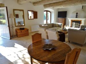 a living room with a wooden table and a couch at very beautiful provencal mas with pool, in the country, between cavaillon and l'isle sur la sorgue - sleeps 10 in Cavaillon