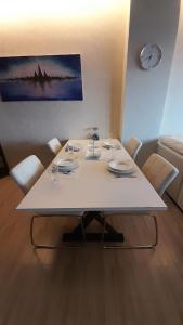 mesa de comedor blanca con sillas y reloj en Seaside Haven Karon, en Ka Rorn